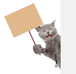 Aufkleber - Happy cat dressed like a doctor with stethoscope on his neck looks from nehind blank white banner and shows blank placard. isolated on white background.