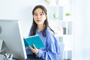 Aufkleber - モダンなオフィスでPCモニターを見ながら作業する女性