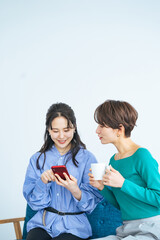 Poster - モダンなリビングでスマホを見る二人の女性