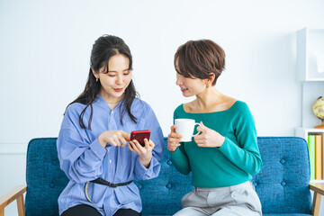 Poster - モダンなリビングでスマホを見る二人の女性