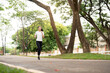 © Natee Meepian - Jogging and Health. Young woman running in a park, showcasing an active lifestyle.