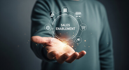 Poster - Person holding sales enablement graphics with icons of business and e commerce elements displayed above