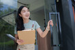 © crizzystudio - Smiling waitress opening the restaurant door, holding clipboard and welcoming customers