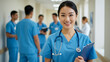 © Cephusni - Smiling Young Asian Female Doctor or Nurse in Hospital Corridor with Medical Team