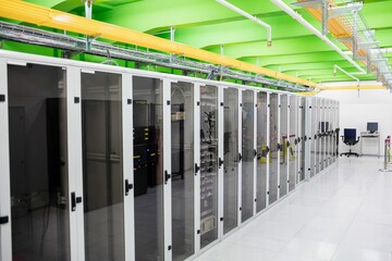 Poster - Illustrating flat datacenter switch racks under yellow trays and beams, raised tiles, desk monitors