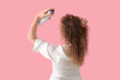 © Pixel-Shot - Beautiful young woman applying hair spray on pink background