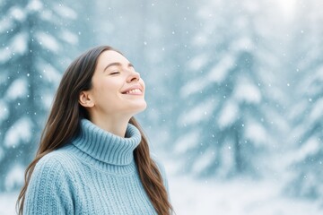 Poster - Woman smiling peacefully in snowfall wearing blue sweater with snowy forest background, expressing calm winter light and joy concept outdoors.