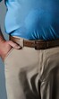© Creative Design  - Caucasian man stands with hand in his tan trousers pocket, wearing a belt