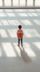 Leinwandbilder - Elementary school student wearing backpack standing in school hallway looking out large window waiting for class to begin on first day back to school