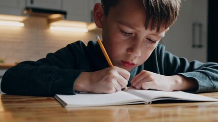 Aufkleber - Concentrated pupil writing in notebook with pencil at wooden table in home interior, diligently completing school assignments or taking notes