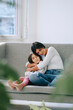 © Westend61 - Mother and daughter hugging on a couch indoors enjoying quality time
