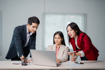 Aufkleber - Three asian businesspeople are discussing working analyzing financial data using laptop computer in office meeting room, teamwork business concept