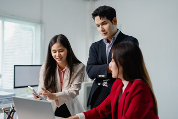 Poster - Three asian businesspeople are working together in a modern office using a calculator and a laptop, discussing a project and collaborating effectively