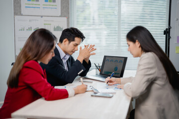 Aufkleber - Marketing team analyzing financial reports displayed on laptop and taking notes during strategy planning meeting in modern office, facing challenges and seeking solutions