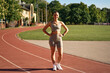 © Valerii Apetroaiei - Young fit woman in sportswear posing on running track