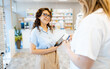 © Zoran Zeremski - Female commercial medical sales representative offering medicine samples to pharmacist at pharmacy.