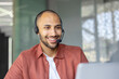 © Liubomir - A smiling man wearing a headset appears to be in a customer service or call center environment, possibly assisting a client.