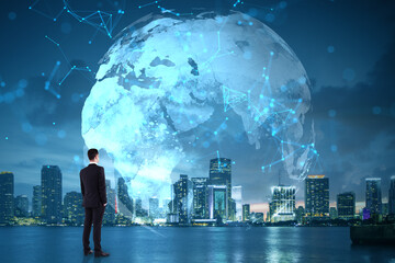 Poster - Businessman looking at digital world map with global network connections over modern city skyline at night, symbolizing internet and technology.
