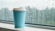 © Владимир Platon - A light blue disposable coffee cup with a white lid rests on a white window sill, with numerous raindrops clinging to the glass in the background, suggesting a cozy indoor moment on a rainy day
