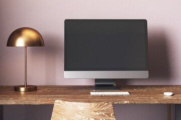 Poster - Modern desktop computer with blank screen on wooden table in cozy home office with lamp and chair against soft wall background. 3D Rendering