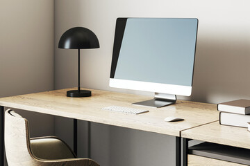 Poster - Modern workspace with blank screen desktop computer, wooden desk, black lamp, and cozy armchair in home office corner environment setup. 3D Rendering