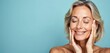 © miss irine - Beautiful middle aged woman with closed eyes touches face skin. Smiling female with perfect skin, facial anti-aging treatment, wellness spa advertising concept. Aging, beauty, skincare products demo