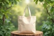 © RESTY - Beige canvas tote bag sits on a wooden stump amidst greenery.