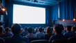 © Atchariya63 - Movie theater audience watching bright blank screen in dark room with blue curtains and soft lighting creating focused atmosphere