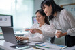 © Wasana - Two women are working on a laptop together