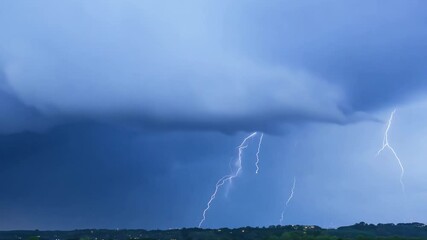 Wall Mural - A striking lightning bolt illuminates the dark sky over a stormy city landscape as rain lashes down