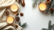 © BgStudio98 - Cozy winter arrangement with candles pinecones anise and knitted blanket on a white background