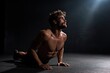 © Abdul - A man doing core exercises on a studio floor with spotlight above dramatic shadow and body definition rubber