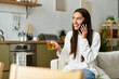 © Bliss - Beautiful young woman enjoys a cozy day at home chatting on her phone with a drink in hand