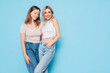 © halayalex - Two young beautiful smiling brunette hipster female in trendy summer clothes. Lovely women posing on blue background in studio. Positive models having fun. Cheerful and happy. isolated