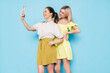 © halayalex - Two young beautiful smiling brunette hipster female in trendy summer clothes. Lovely women posing on blue background in studio. Positive models having fun. Cheerful and happy. Take selfie
