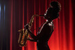 © pressmaster - African American woman playing saxophone on stage in front of red curtain, standing in profile with hair in dreadlocks, performing jazz music as professional musician
