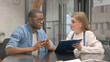 © stockbakers - Female Doctor Sharing Positive Medical Report with Anxious African Patient