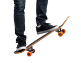 Person in jeans and sneakers performing skateboard trick with orange wheels on wooden board deck