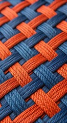 close up of woven orange and blue rope pattern abstract texture background with interlaced strands a