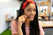 © WavebreakMediaMicro - Woman smiling and speaking into headset microphone at desk in modern open-plan office workspace