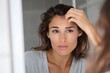 © Warakorn - Woman looking in mirror after forehead injection