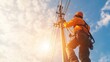 © fotofabrika - Utility worker repairs power lines against a backdrop of a bright blue sky during late afternoon