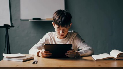 Aufkleber - Concentrated student engaging with digital learning, seated at classroom desk surrounded by educational materials, utilizing tablet for online educational experience