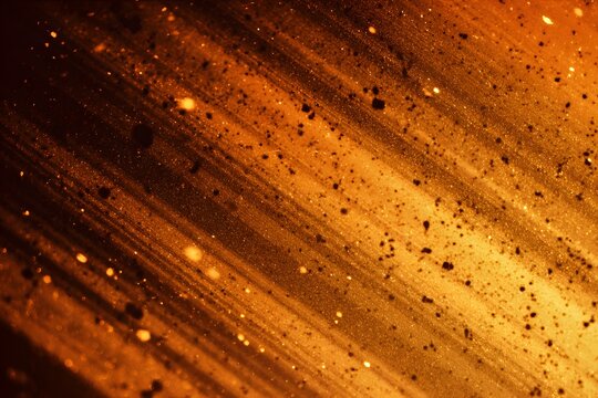 A close-up of an orange and black background with streaks of light, creating the illusion that they are moving in all directions. 