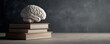 © ParinApril - Conceptual Brain on Stack of Books Symbolizing Knowledge, Learning, and Education in Human Mind