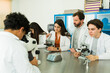 © AntonioDiaz - High school students learning biology using microscopes in laboratory with the help of their teacher