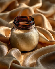 Poster - Small glass jar with brown rim on golden satin fabric in soft sunlight