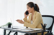 © Kritdanai - Business Woman on a Call: A dynamic shot capturing a focused businesswoman, engrossed in a phone call at her desk, showcasing her efficiency and commitment to success.