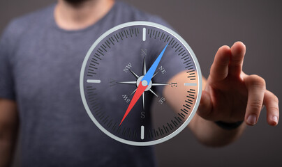 Poster - Stock photo of a man interacting with a digital compass, symbolizing guidance and direction.