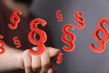 Poster - Red paragraph symbols hover near a hand, suggesting legal concepts or law.